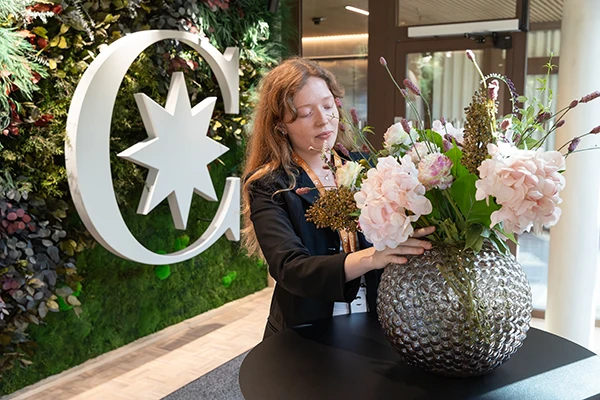 receptionist som ordnar blomsterarrangemang p&aring; Coors huvudkontor